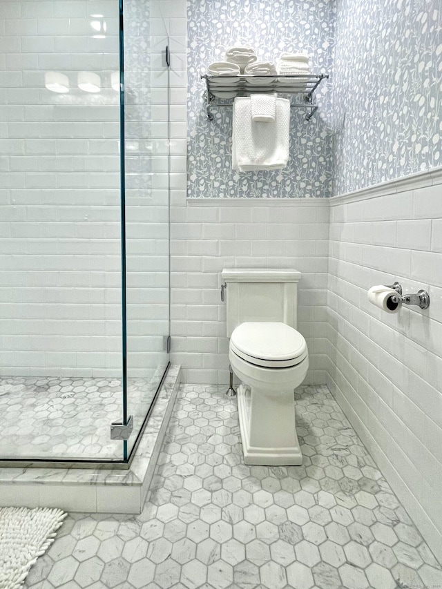 506 Jamestown Rd Unit 506, Stratford, CT 06614 - full bathroom with wallpapered walls, a shower stall, a wainscoted wall, toilet, and tile walls