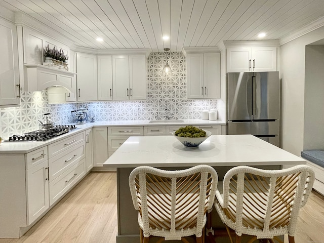 506 Jamestown Rd Unit 506, Stratford, CT 06614 - kitchen featuring appliances with stainless steel finishes, light wood-style floors, a breakfast bar, white cabinetry, and backsplash