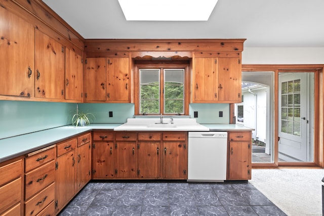 10 Wyndwood Rd, West Hartford, CT 06107 - kitchen featuring white dishwasher, light countertops, brown cabinets, and a skylight