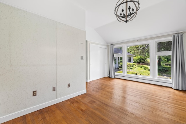 10 Wyndwood Rd, West Hartford, CT 06107 - empty room with baseboard heating, vaulted ceiling, a chandelier, and wood finished floors