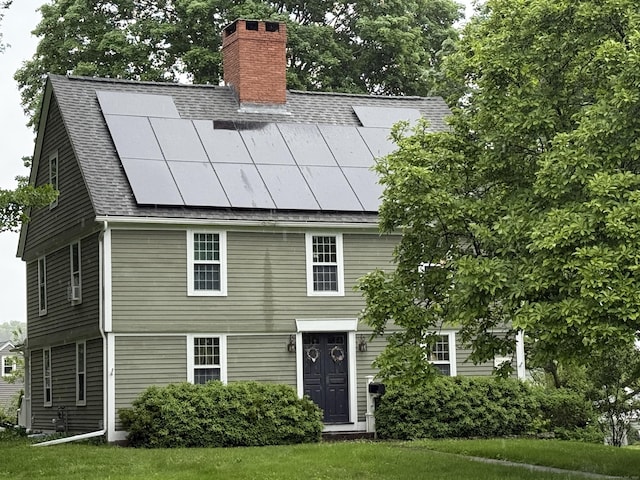 64 W St, Cromwell, CT 06416 - view of front of house featuring a chimney, roof with shingles, and solar panels