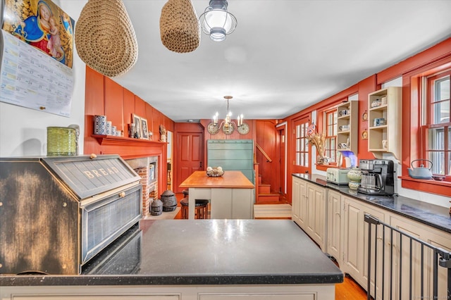64 W St, Cromwell, CT 06416 - kitchen with dark countertops, open shelves, a chandelier, cream cabinets, and wooden walls