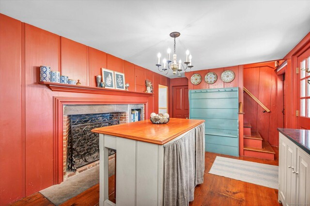 64 W St, Cromwell, CT 06416 - kitchen featuring dark wood finished floors, a fireplace, a chandelier, pendant lighting, and a center island