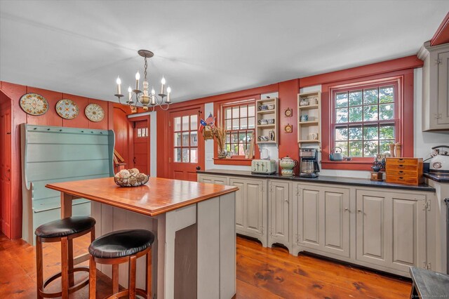 64 W St, Cromwell, CT 06416 - kitchen with wood-type flooring, a chandelier, a center island, a breakfast bar, and pendant lighting
