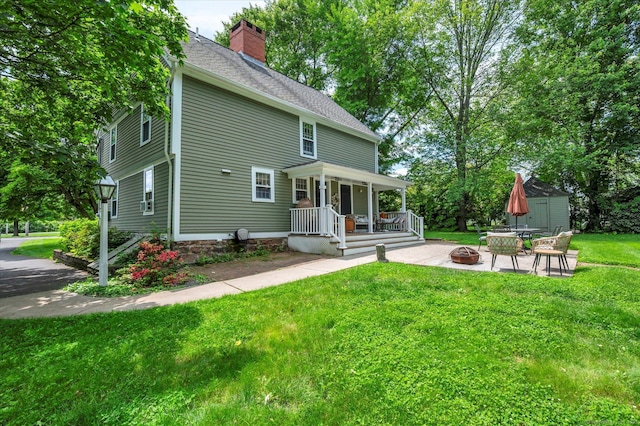 64 W St, Cromwell, CT 06416 - view of front facade with a fire pit, a front lawn, a chimney, and covered porch