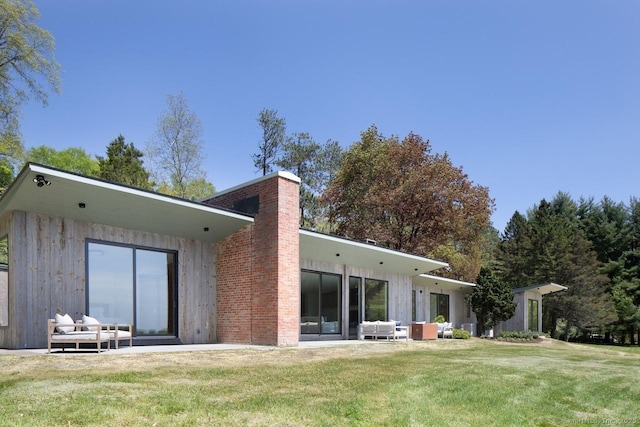 136 Belgo Rd, Salisbury, CT 06039 - rear view of house with a chimney, a lawn, a patio, and an outdoor hangout area