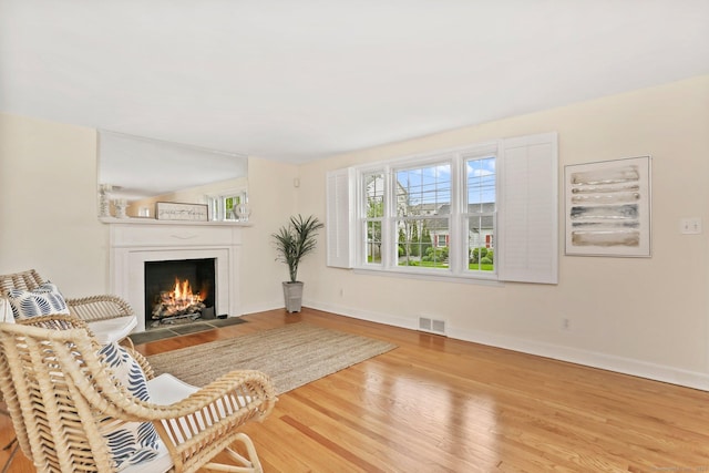 102 Pratt St, Fairfield, CT 06824 - living room featuring a fireplace with flush hearth, wood finished floors, and baseboards