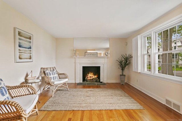 102 Pratt St, Fairfield, CT 06824 - sitting room with a fireplace with flush hearth, wood finished floors, and baseboards