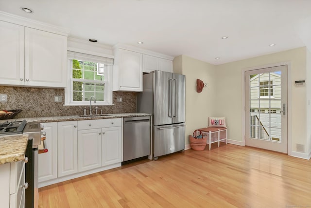 102 Pratt St, Fairfield, CT 06824 - kitchen with appliances with stainless steel finishes, a sink, light wood finished floors, white cabinets, and recessed lighting