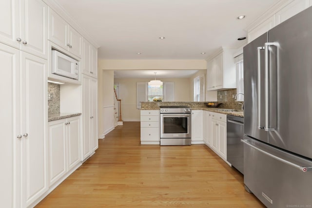 102 Pratt St, Fairfield, CT 06824 - kitchen featuring stainless steel appliances, a peninsula, tasteful backsplash, light wood-type flooring, and recessed lighting