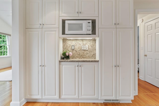 102 Pratt St, Fairfield, CT 06824 - kitchen featuring white microwave, light wood-style floors, and white cabinets