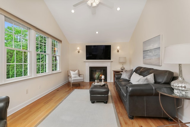 102 Pratt St, Fairfield, CT 06824 - living area featuring lofted ceiling, wood finished floors, a ceiling fan, a glass covered fireplace, and baseboards