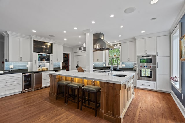 18 Ferry Rd, Old Lyme, CT 06371 - kitchen with wine cooler, a sink, tasteful backsplash, a large island, and ornamental molding