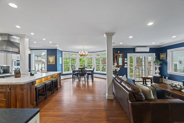 18 Ferry Rd, Old Lyme, CT 06371 - living room with crown molding, a wall mounted AC, dark wood finished floors, a baseboard heating unit, and a chandelier