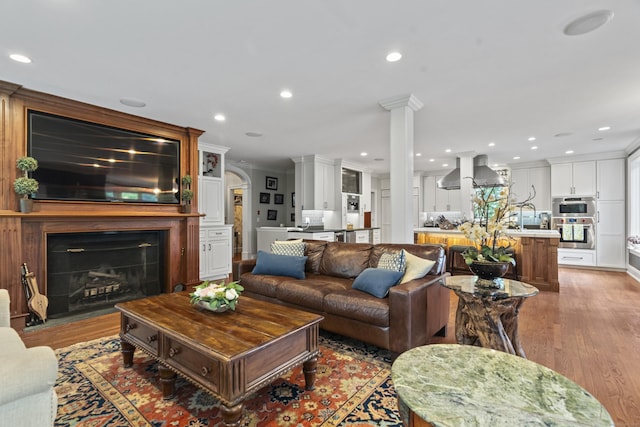 18 Ferry Rd, Old Lyme, CT 06371 - living room featuring light wood-style flooring, a fireplace, recessed lighting, ornate columns, and crown molding