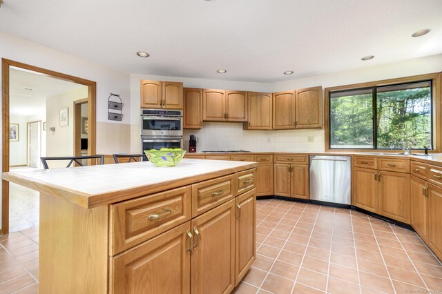 17 Walker Ln, Weston, CT 06883 - kitchen featuring appliances with stainless steel finishes, tile countertops, decorative backsplash, a sink, and light tile patterned flooring