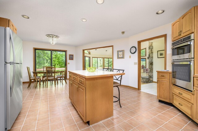 17 Walker Ln, Weston, CT 06883 - kitchen featuring stainless steel appliances, a kitchen breakfast bar, recessed lighting, a kitchen island, and light tile patterned floors