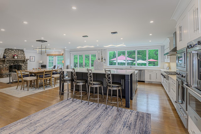 368 Nod Hill Rd, Wilton, CT 06897 - kitchen with healthy amount of natural light, white cabinetry, wall chimney exhaust hood, light countertops, and recessed lighting