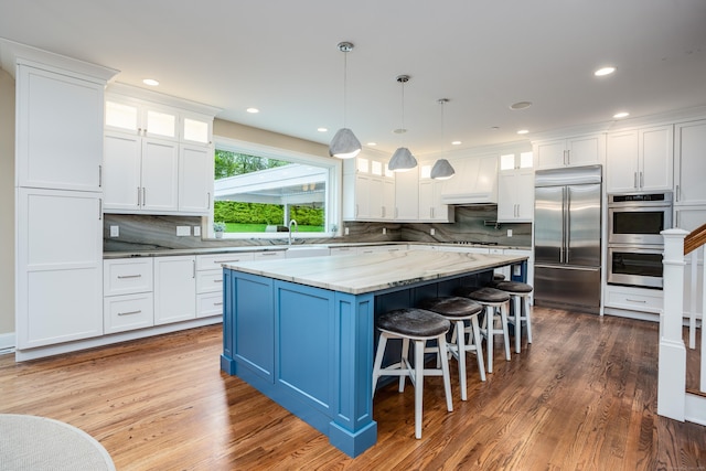 15A Shore Rd, Waterford, CT 06385 - kitchen featuring appliances with stainless steel finishes, white cabinetry, decorative backsplash, a center island, and glass insert cabinets