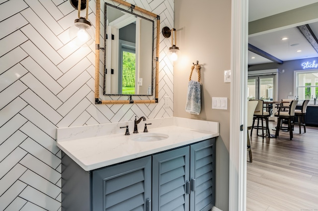 15A Shore Rd, Waterford, CT 06385 - bathroom featuring vanity, wood finished floors, tasteful backsplash, and beam ceiling