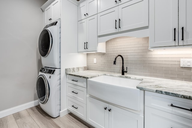 15A Shore Rd, Waterford, CT 06385 - laundry room featuring estacked washer and dryer, cabinet space, and light wood-style floors
