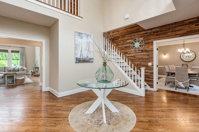 15A Shore Rd, Waterford, CT 06385 - entrance foyer featuring stairs, wood finished floors, a high ceiling, wooden walls, and a chandelier