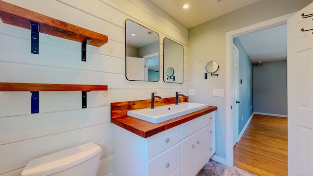 23 Bartlett Mnr, Norwalk, CT 06850 - half bath featuring toilet, vanity, baseboards, recessed lighting, and wood finished floors