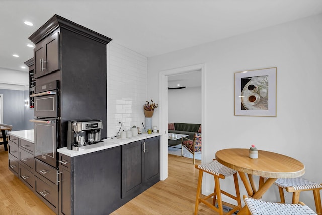2 Quanaduck Cove Ct Unit 2, Stonington, CT 06378 - kitchen featuring light wood-style flooring, light countertops, backsplash, double oven, and recessed lighting