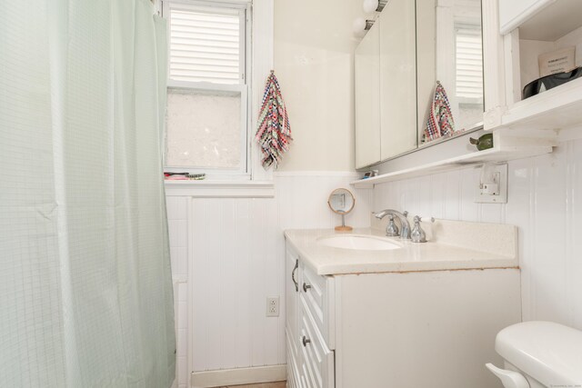 76 Edwards St, New Haven, CT 06511 - bathroom featuring a wainscoted wall, vanity, toilet, a decorative wall, and curtained shower