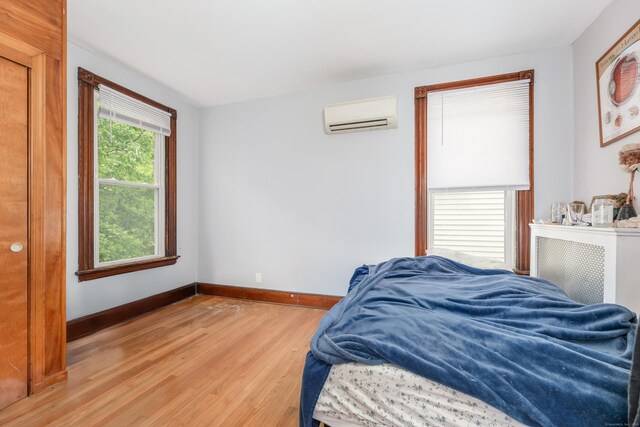 76 Edwards St, New Haven, CT 06511 - bedroom with a wall unit AC, light wood-style flooring, and baseboards