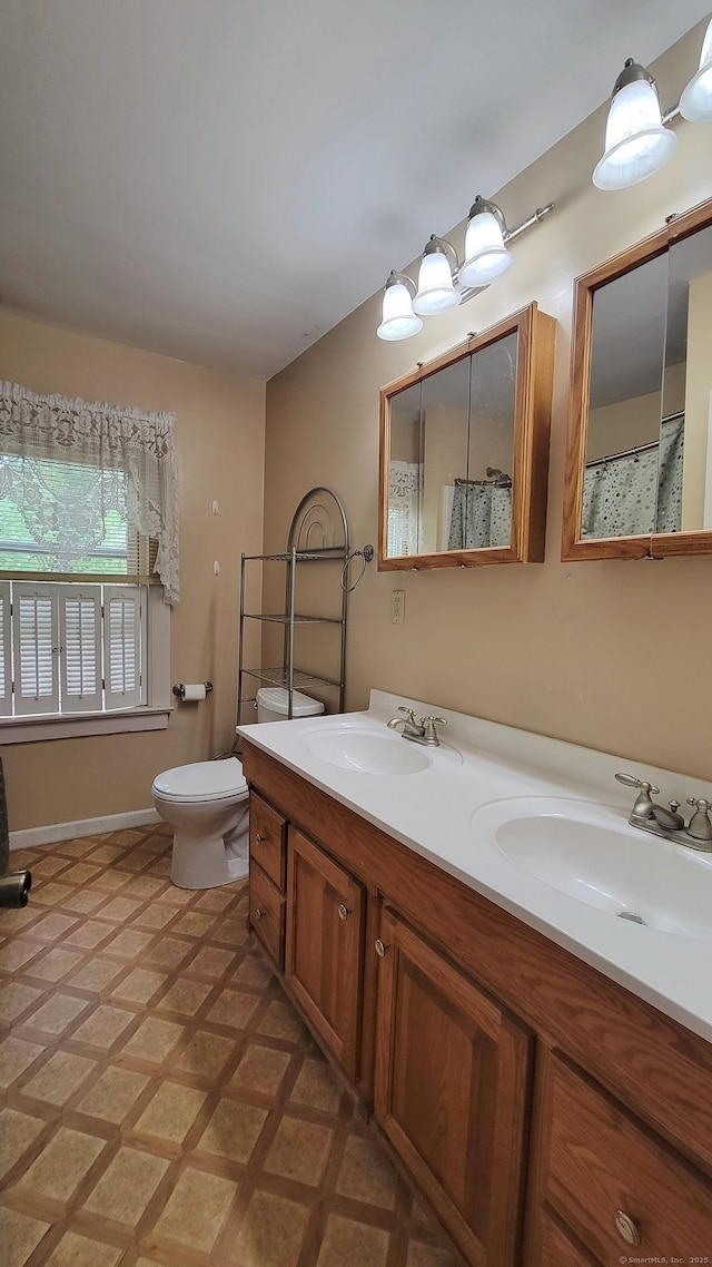 909 N Colony Rd, Meriden, CT 06450 - full bathroom with double vanity, toilet, and baseboards