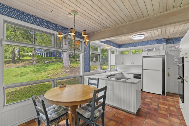 1 Indian Spring Ln, Norwich, CT 06360 - kitchen with freestanding refrigerator, black electric stovetop, wood ceiling with exposed beams, a peninsula, and light countertops