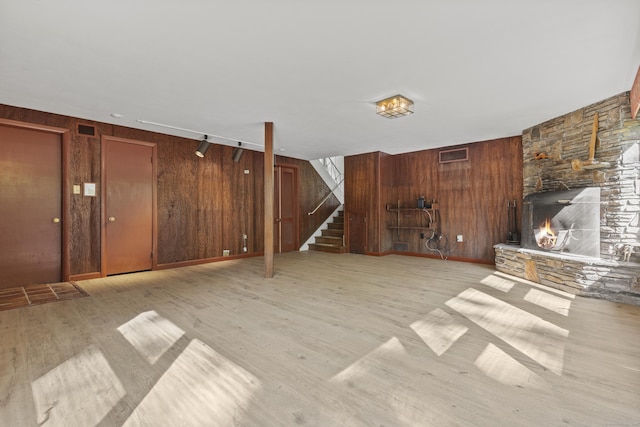 1 Indian Spring Ln, Norwich, CT 06360 - unfurnished living room with light wood-style flooring, stairs, and wooden walls