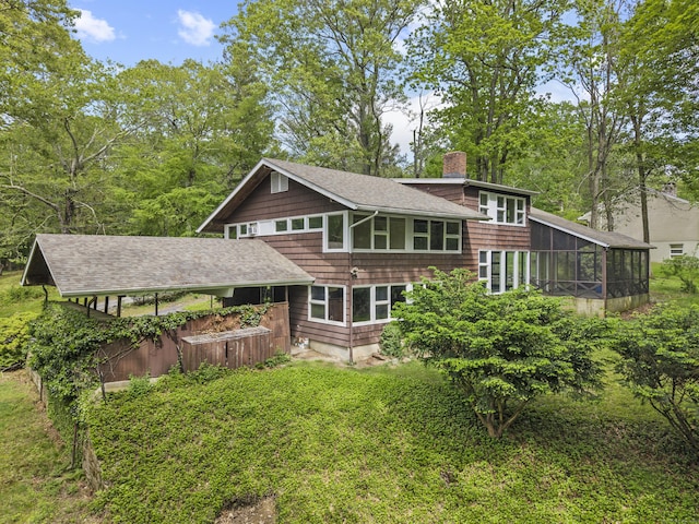 1 Indian Spring Ln, Norwich, CT 06360 - back of property featuring a sunroom, a chimney, and a shingled roof