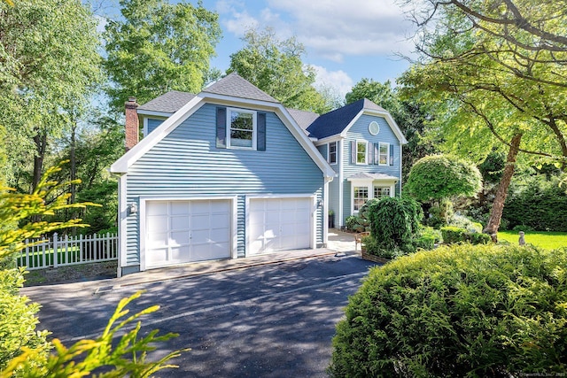 23 Mckeon Pl, Ridgefield, CT 06877 - view of front facade featuring asphalt driveway, a chimney, and a shingled roof