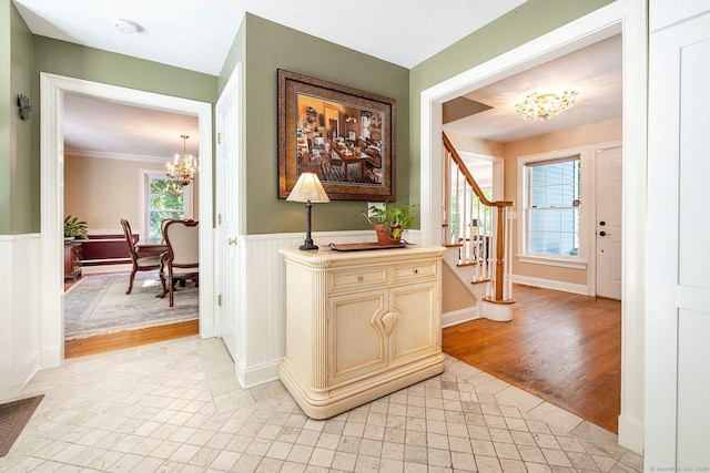 23 Mckeon Pl, Ridgefield, CT 06877 - hall with a chandelier, stairs, wainscoting, light tile patterned floors, and crown molding