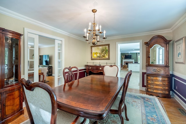 23 Mckeon Pl, Ridgefield, CT 06877 - dining area with a chandelier, crown molding, light wood-type flooring, and french doors