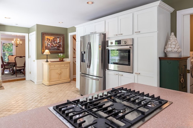 23 Mckeon Pl, Ridgefield, CT 06877 - kitchen featuring stainless steel appliances, a chandelier, white cabinets, wainscoting, and recessed lighting