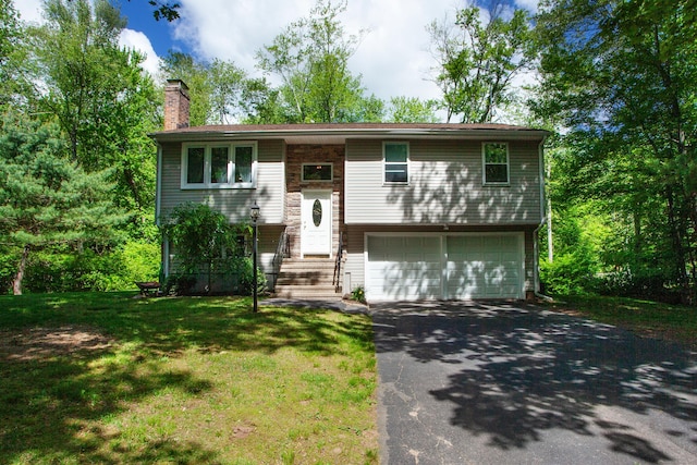 69 Fernwood Dr, Simsbury, CT 06070 - raised ranch featuring asphalt driveway, an attached garage, a chimney, and a front yard