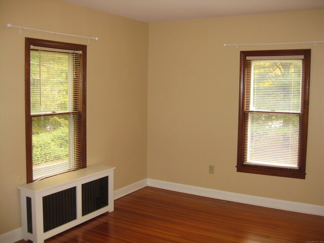 1071 River Blvd, Suffield, CT 06078 - spare room featuring dark wood-style floors, healthy amount of natural light, baseboards, and radiator