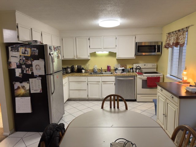 47 Conestoga Way Unit 47, Glastonbury, CT 06033 - kitchen with appliances with stainless steel finishes, a sink, light tile patterned floors, white cabinetry, and a textured ceiling