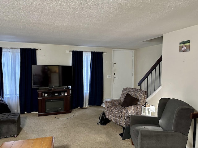 47 Conestoga Way Unit 47, Glastonbury, CT 06033 - carpeted living room featuring a textured ceiling, stairway, and a glass covered fireplace