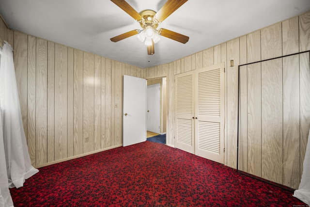 34 Benedict Dr, South Windsor, CT 06074 - unfurnished bedroom featuring wood walls, carpet flooring, and a ceiling fan