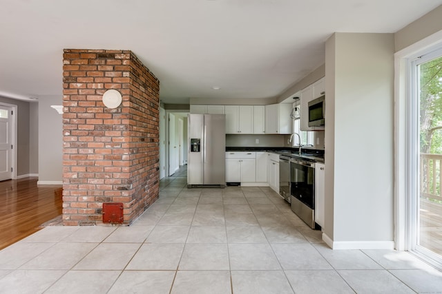 143 Clark Hill Rd, East Haddam, CT 06423 - kitchen featuring appliances with stainless steel finishes, dark countertops, white cabinets, a sink, and light tile patterned floors