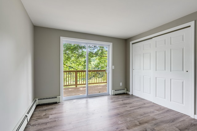 143 Clark Hill Rd, East Haddam, CT 06423 - unfurnished bedroom featuring access to outside, baseboard heating, wood finished floors, and a closet