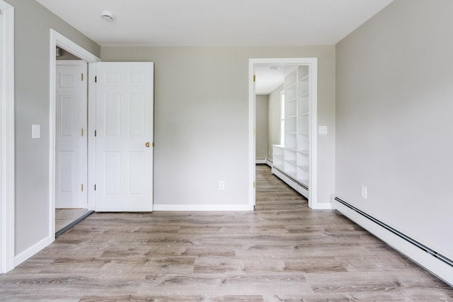 143 Clark Hill Rd, East Haddam, CT 06423 - empty room with a baseboard heating unit, wood finished floors, built in features, and baseboards