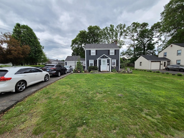 1437 Silver Ln, East Hartford, CT 06118 - colonial home with a front yard, a chimney, and a garage