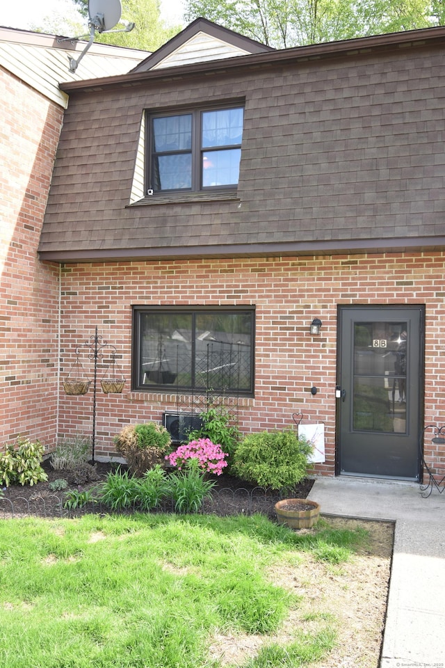 143 Pine Hill Rd Unit 8B, Thomaston, CT 06787 - property entrance featuring a shingled roof, mansard roof, brick siding, and a lawn