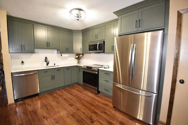 143 Pine Hill Rd Unit 8B, Thomaston, CT 06787 - kitchen with appliances with stainless steel finishes, a sink, light countertops, dark wood-style flooring, and green cabinets