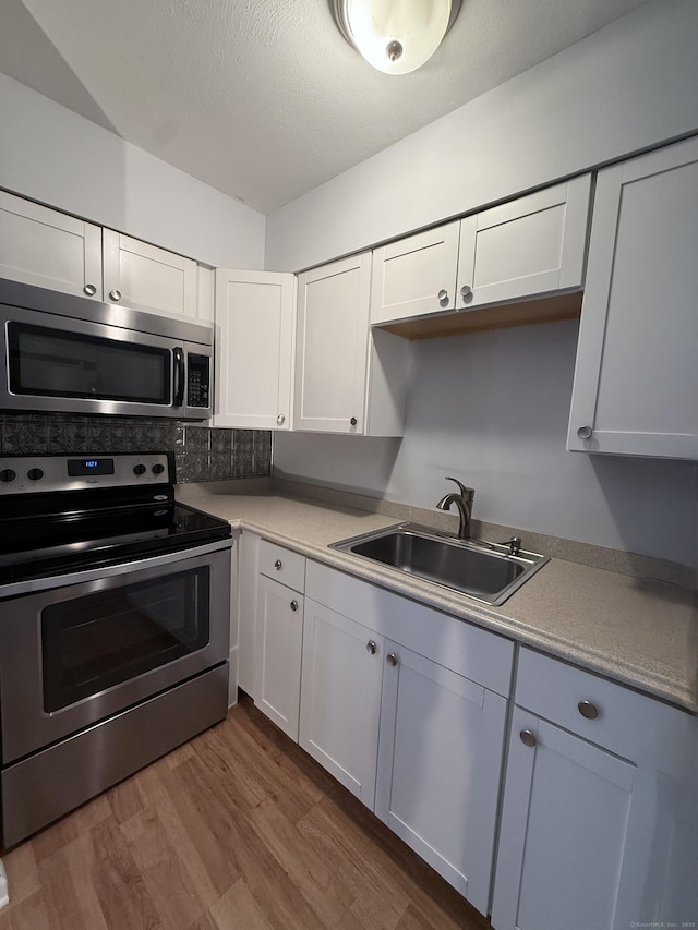 1105 Waterbury Rd Apt 1B, Cheshire, CT 06410 - kitchen featuring appliances with stainless steel finishes, dark wood-type flooring, white cabinets, light countertops, and backsplash